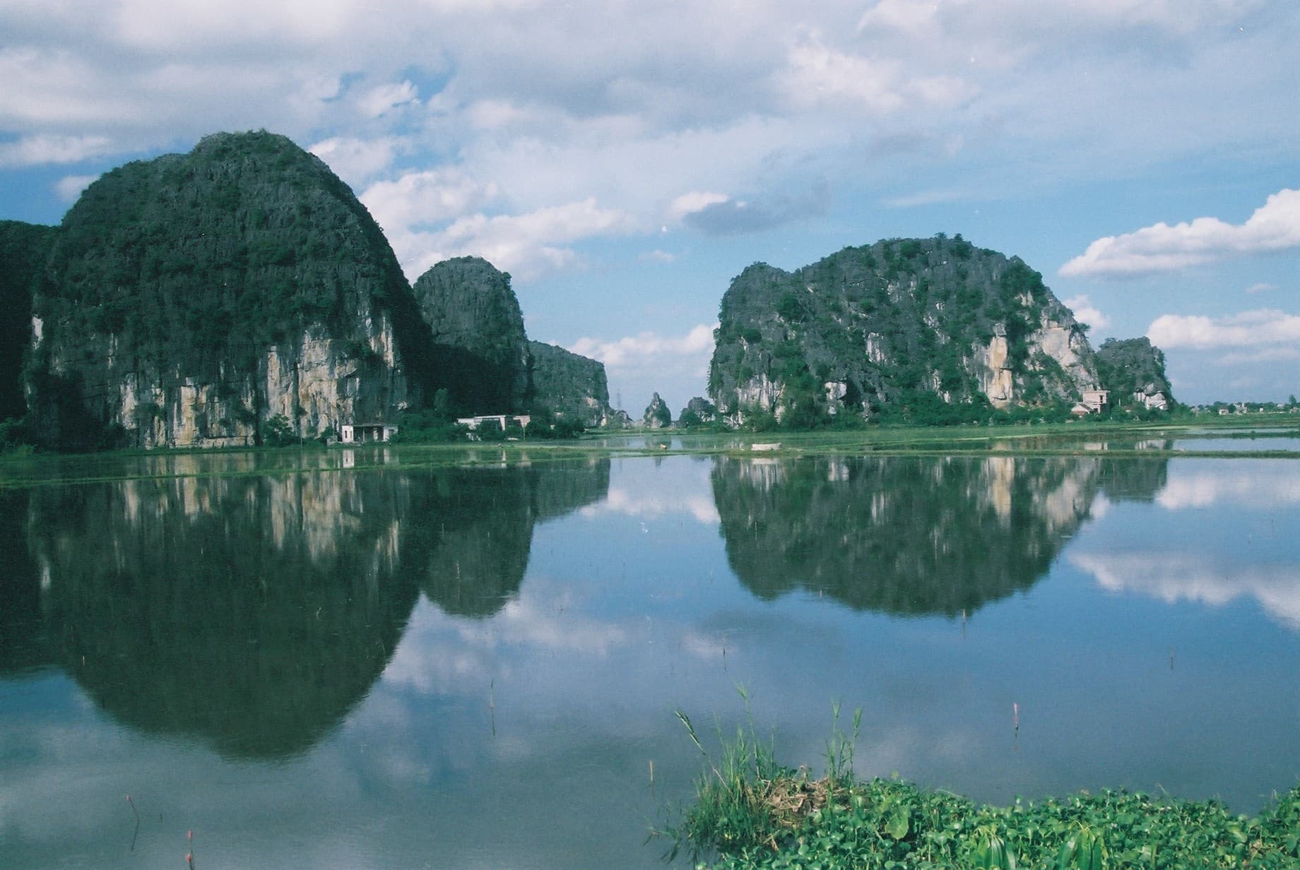 Kalksteenrotsen weerspiegelen in het water bij Ninh Binh